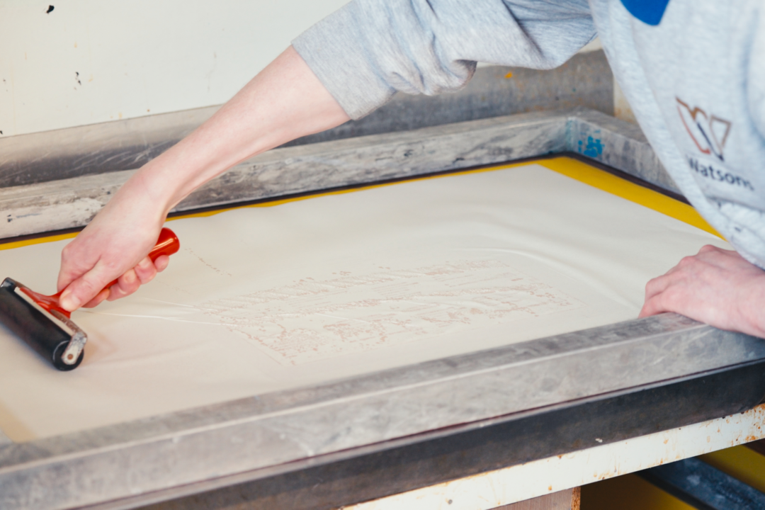 person using a hand held roller whilst printing